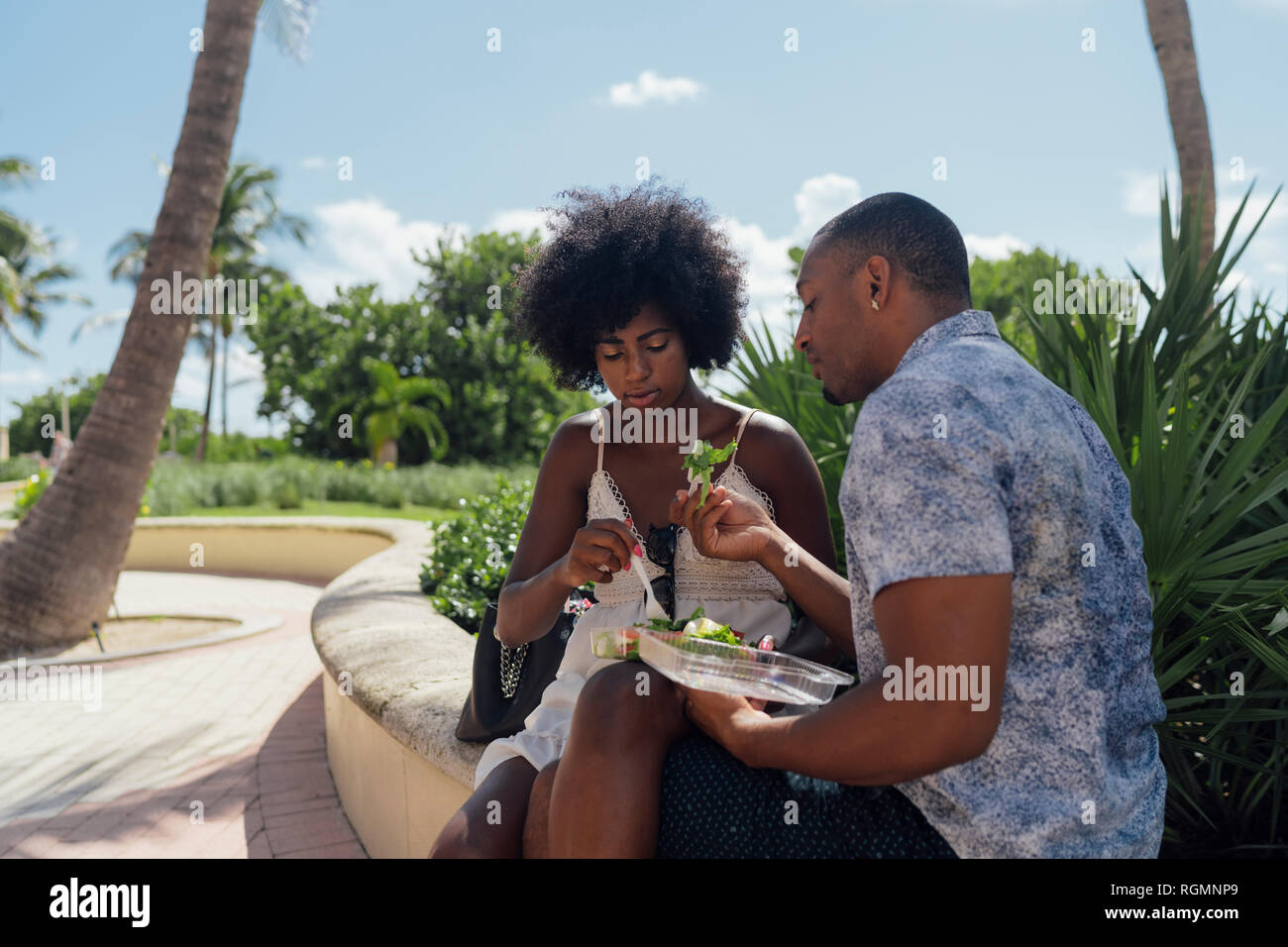 Stati Uniti d'America, Florida, Miami Beach, coppia giovane la condivisione di un insalata in un parco Foto Stock