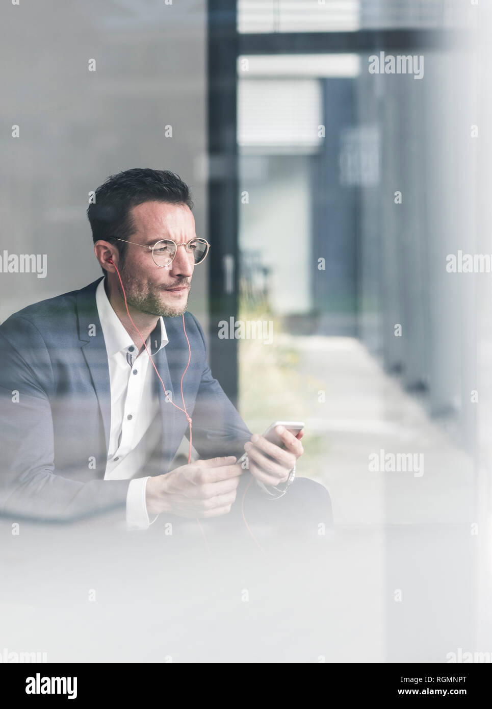 Imprenditore a parlare al telefono, utilizzare auricolari Foto Stock