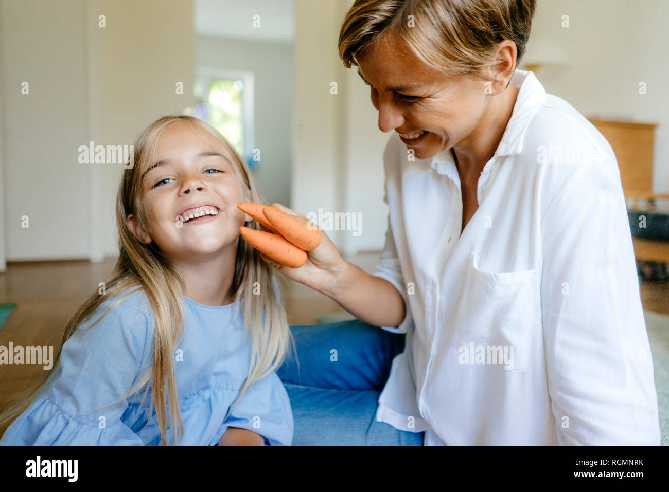 Felice madre e figlia con le carote a casa Foto Stock
