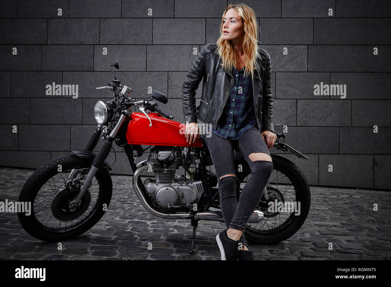 Fiducioso giovane donna con la motocicletta che guarda lontano Foto Stock