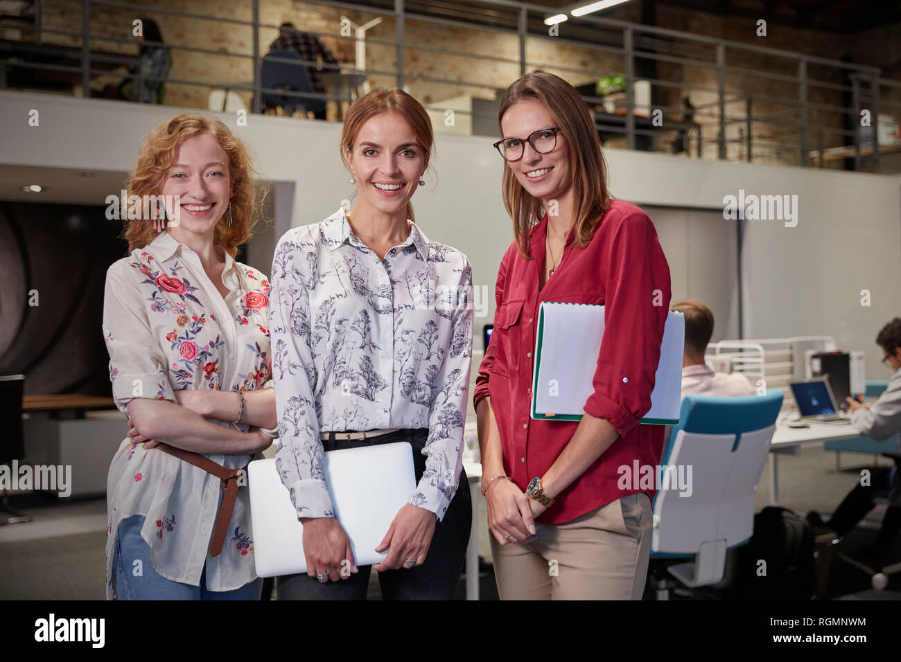 Gruppo ritratti femminili di colleghi in ufficio, tenendo i file Foto Stock