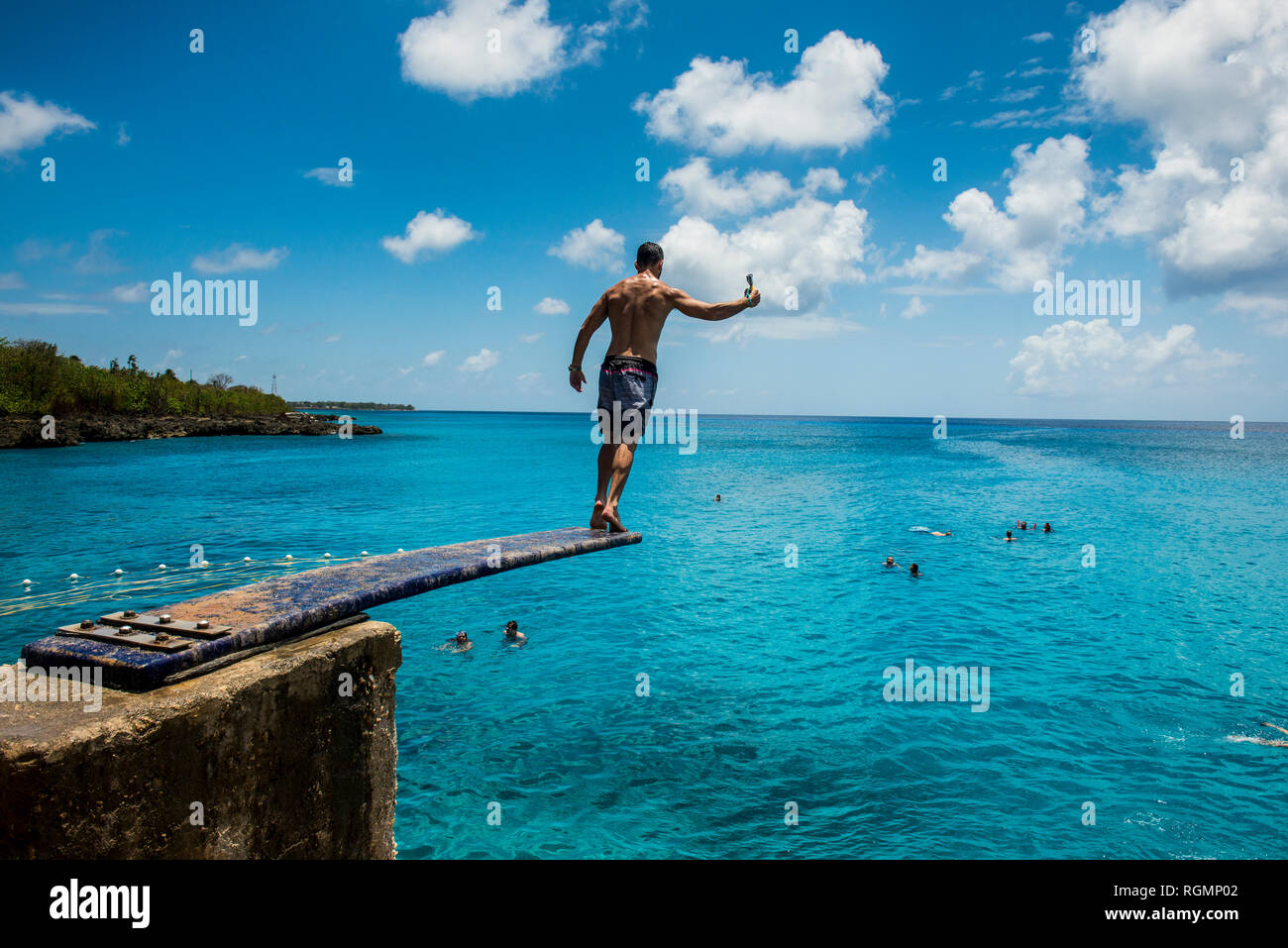 Caraibi, Colombia, San Andres, uomo sul trampolino sopra l'acqua turchese Foto Stock