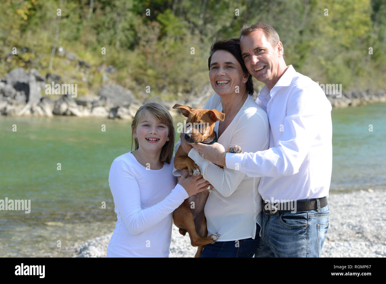 La famiglia felice con un cane al fiume Isar, Alta Baviera, Germania Foto Stock