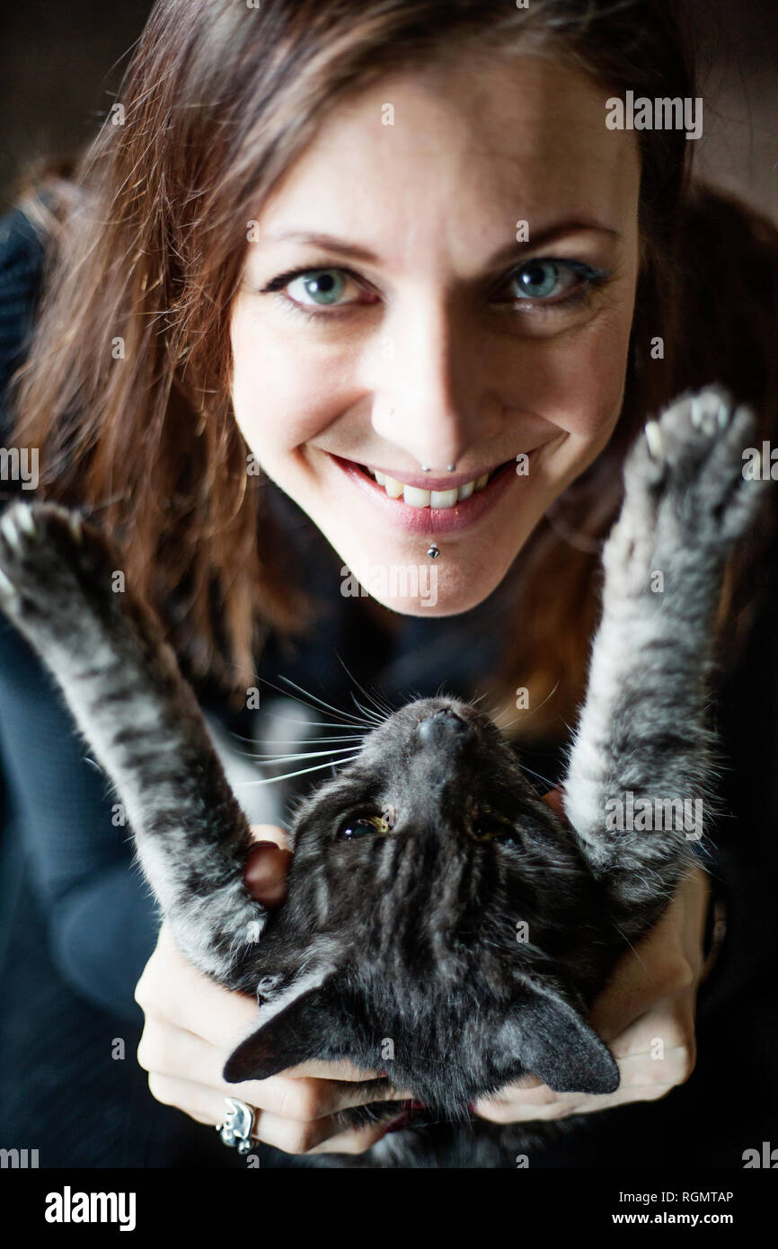 Ritratto di donna sorridente e il suo grigio tabby cat Foto Stock