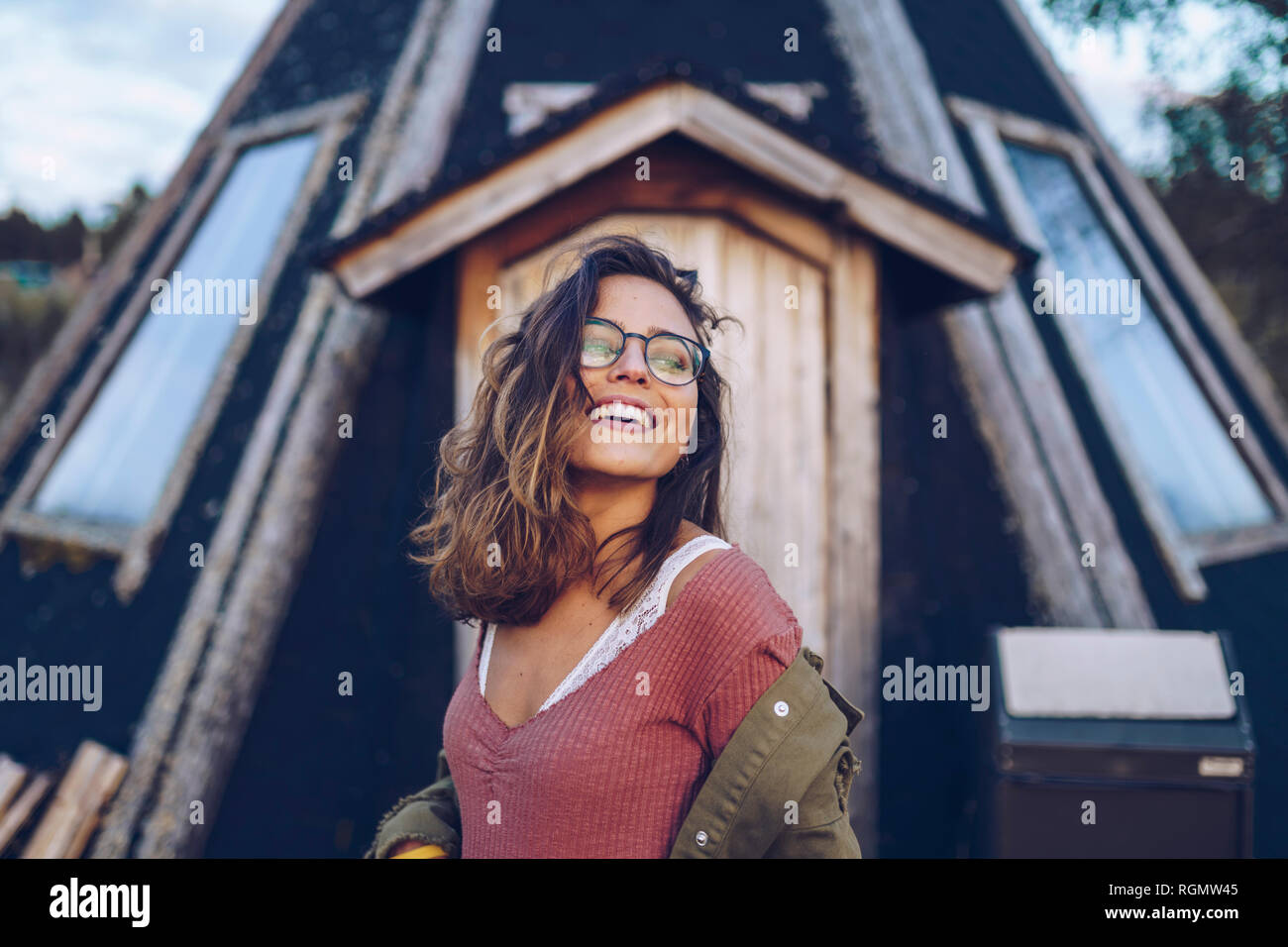 Ritratto di una ridente giovane donna di fronte a casa finlandese Foto Stock