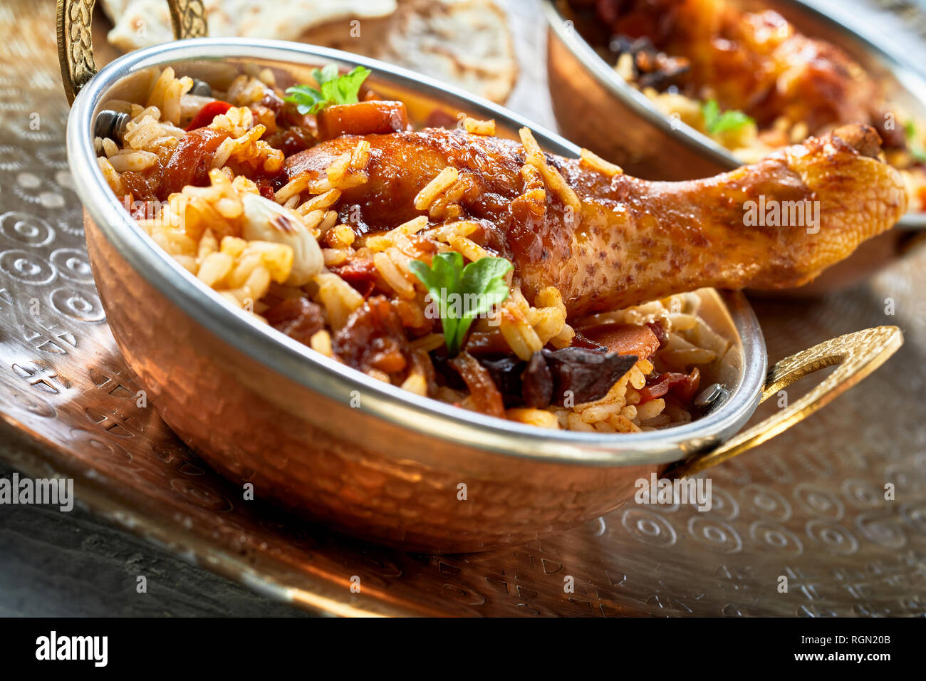 Piccante condita kabsa Arabian food bowl con assortimento di verdure e carne in lunghi grana di riso Basmati guarnita con erbe aromatiche fresche in un angolo inclinato vie Foto Stock