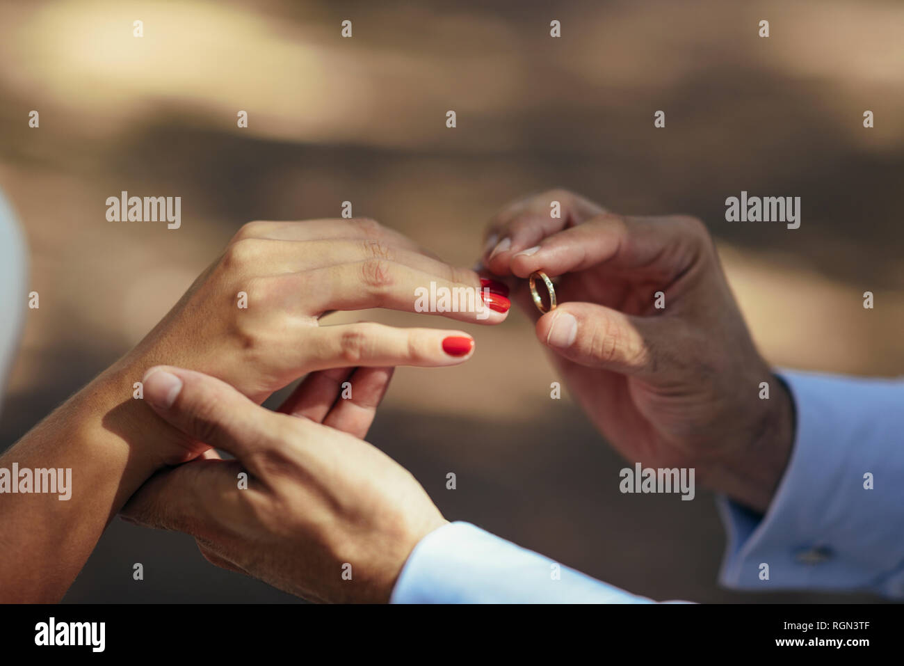 Lo sposo di mettere l'anello nuziale sul dito della sposa, close up Foto Stock
