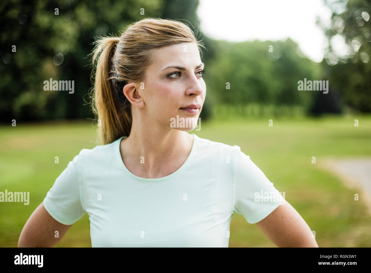 Ritratto di giovane sportivo donna in un parco alla ricerca lateralmente Foto Stock