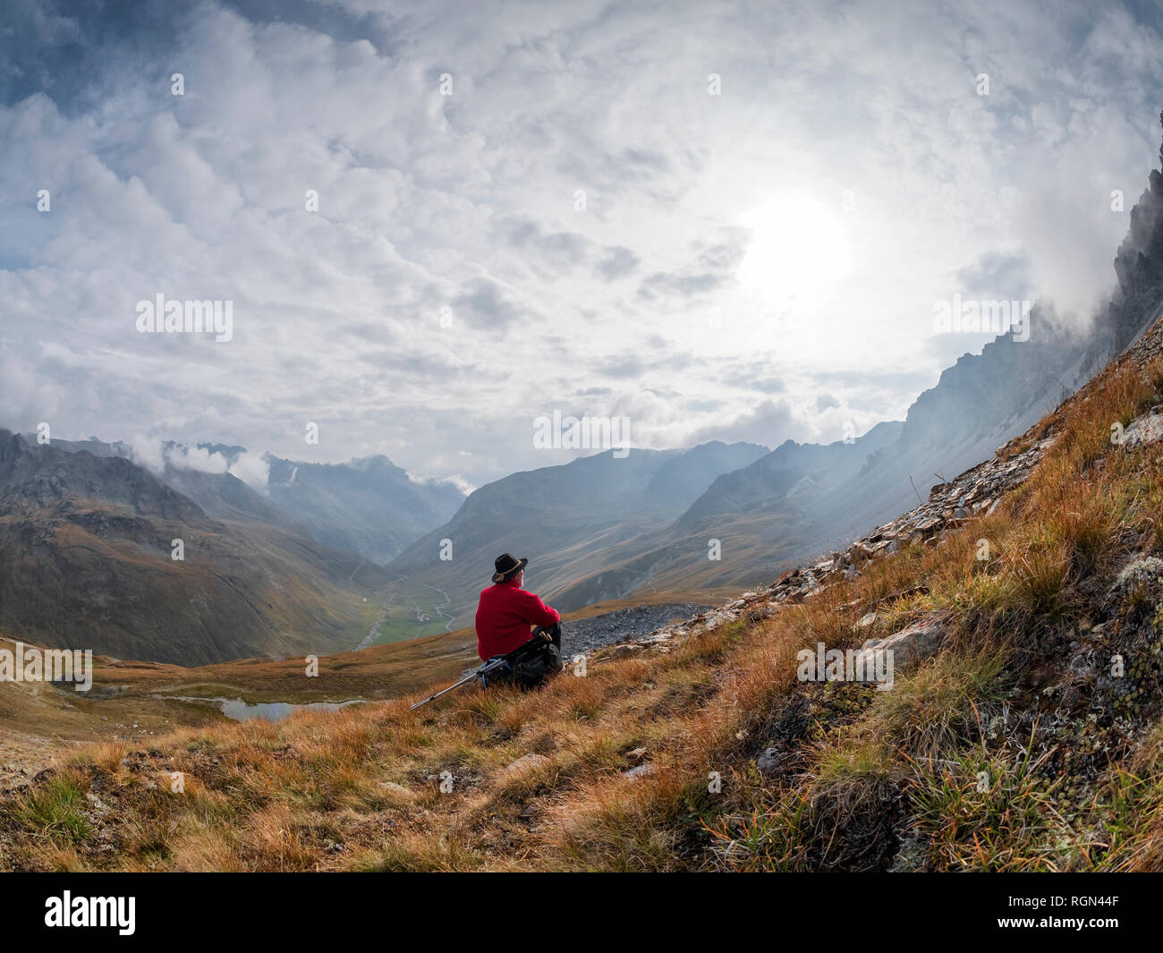 La regione di bordo Italia Svizzera, senior uomo avente una pausa dalle escursioni nel paesaggio di montagna al Piz Umbrail Foto Stock