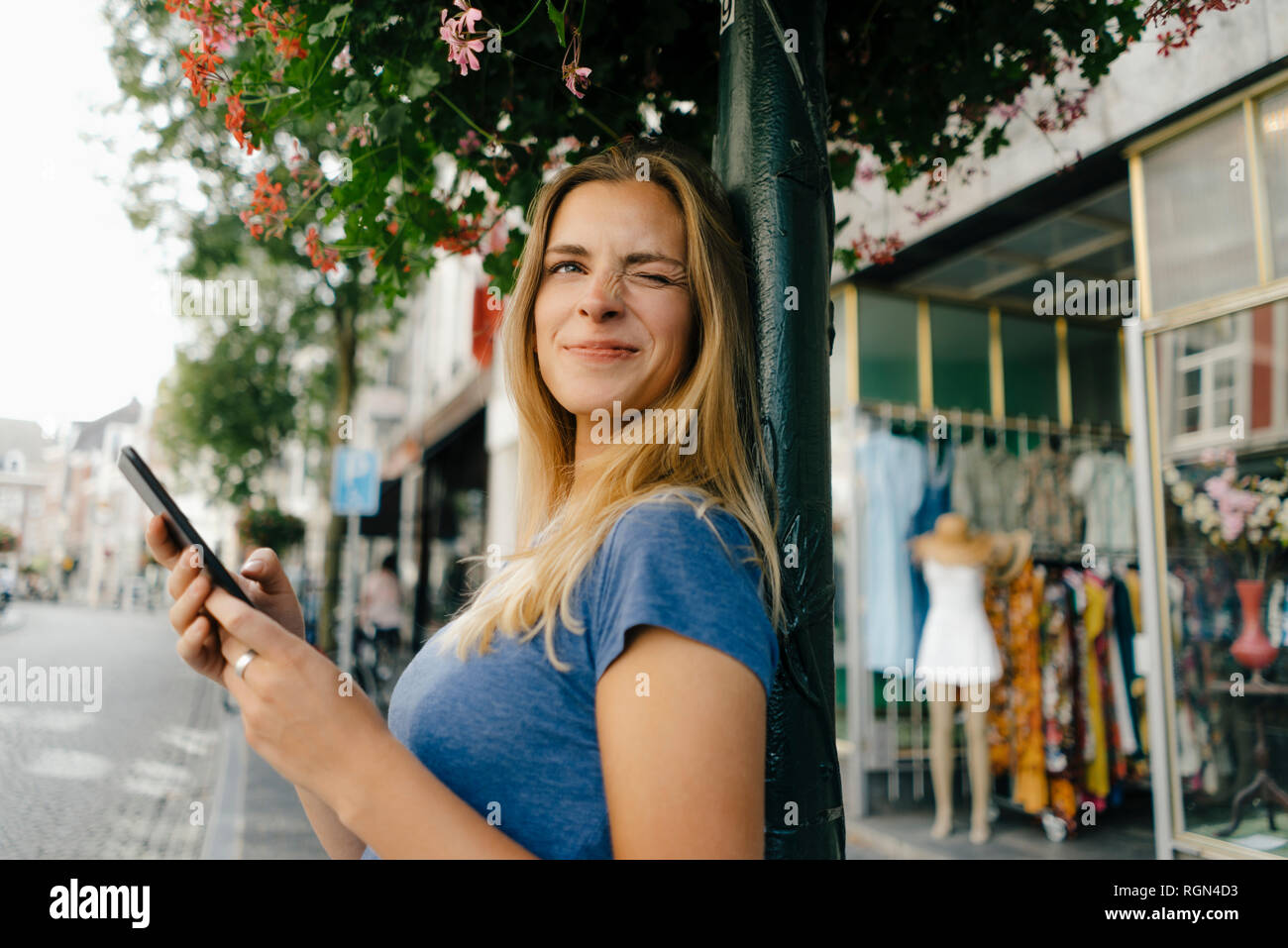 Paesi Bassi, Maastricht, sorridente ragazza con un telefono cellulare nella città scintillanti Foto Stock