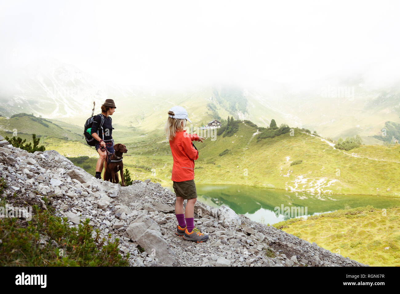 Austria, Alto Adige, figlia della madre e cane sul sentiero escursionistico Foto Stock