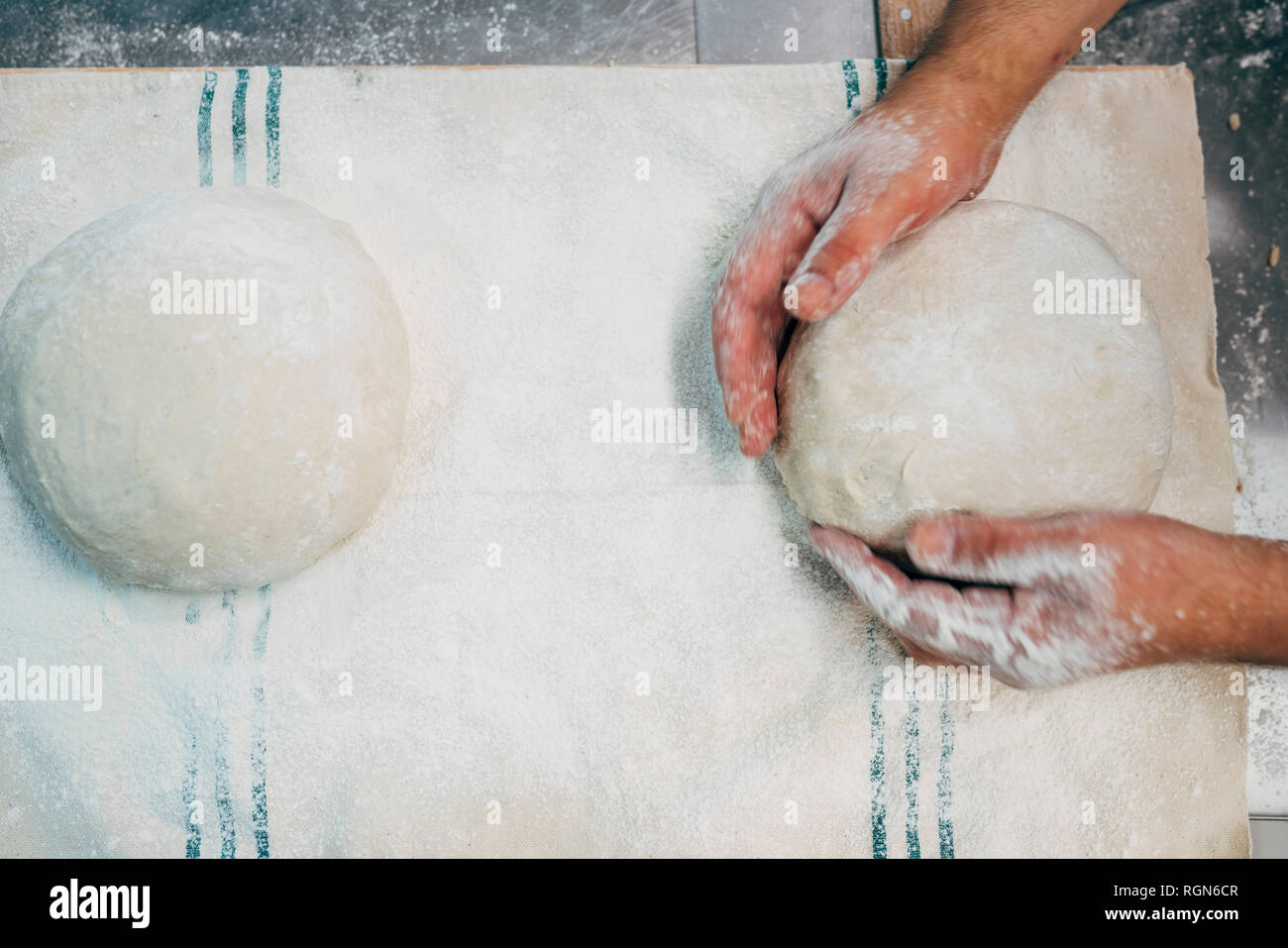 Baker lavora con impasto in forno Foto Stock