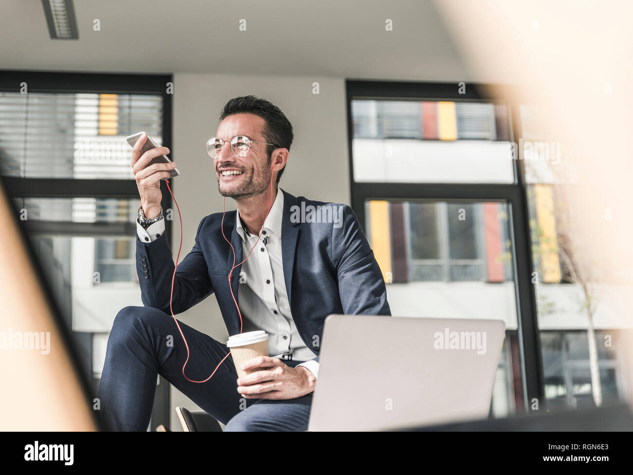 Imprenditore a parlare al telefono, utilizzare auricolari Foto Stock