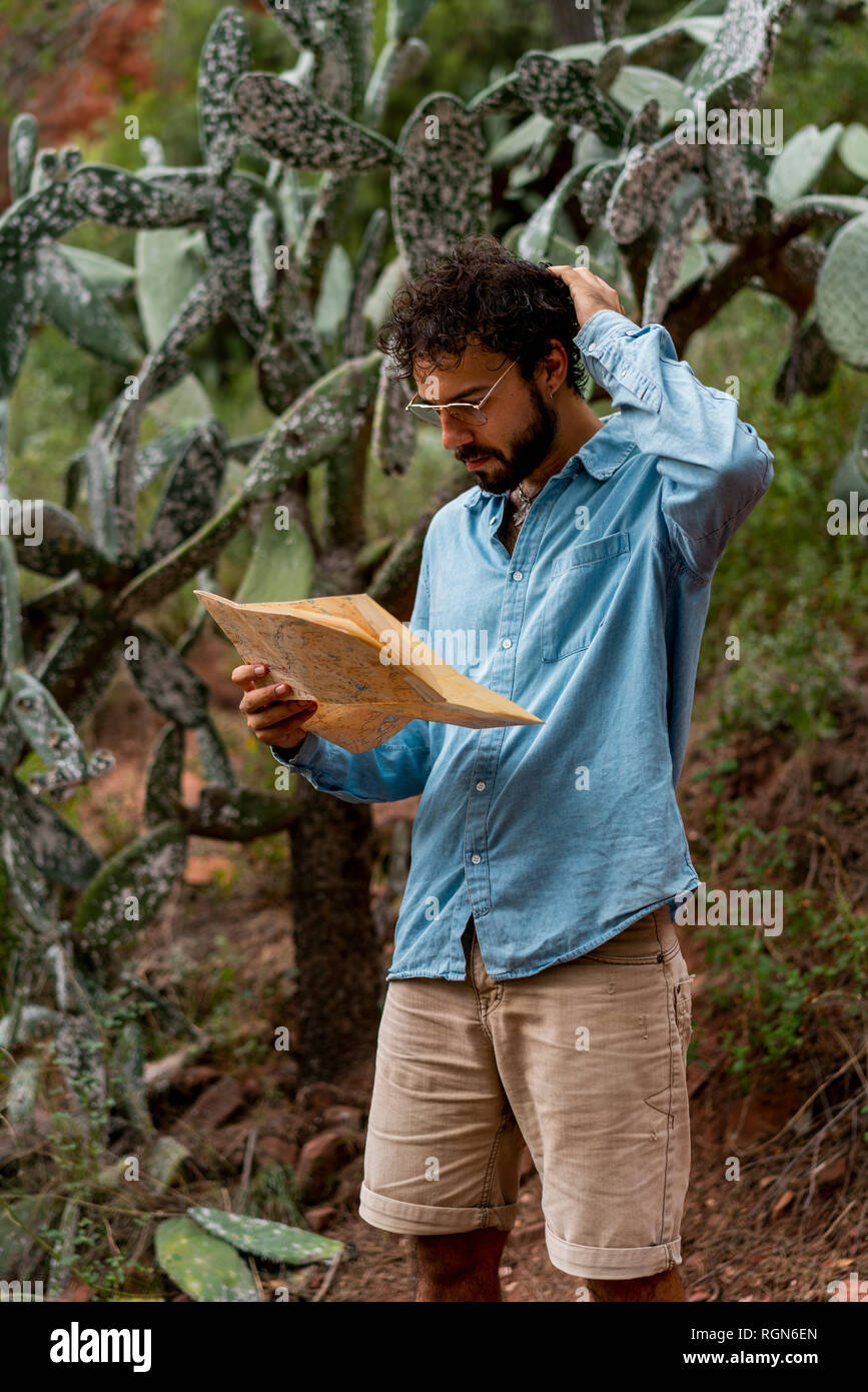 Giovane uomo in piedi in natura, guardando alla mappa Foto Stock