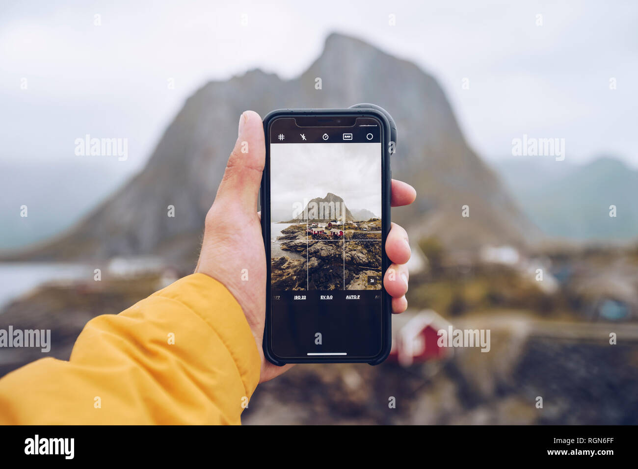 Norvegia Lofoten, Hamnoy, mano azienda smartphone per scattare la foto Foto Stock