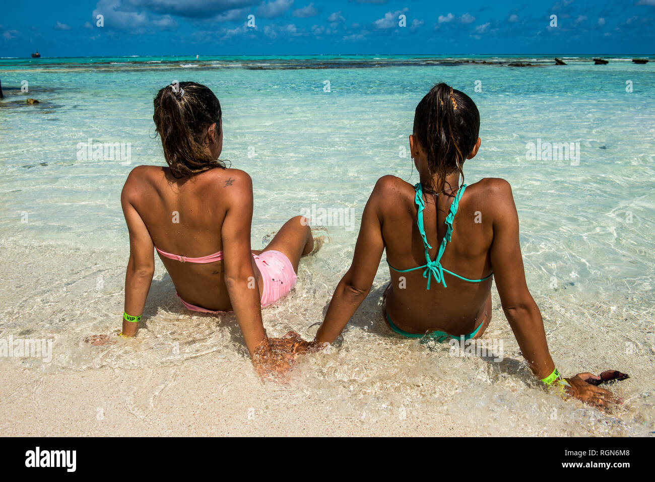 Caraibi, Colombia, San Andres, El Acuario, vista posteriore di due donne sedute in acqua poco profonda Foto Stock