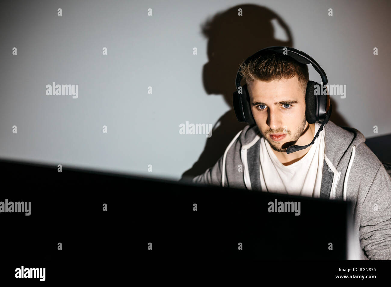 Giovane uomo seduto al PC, i giochi per computer Foto Stock