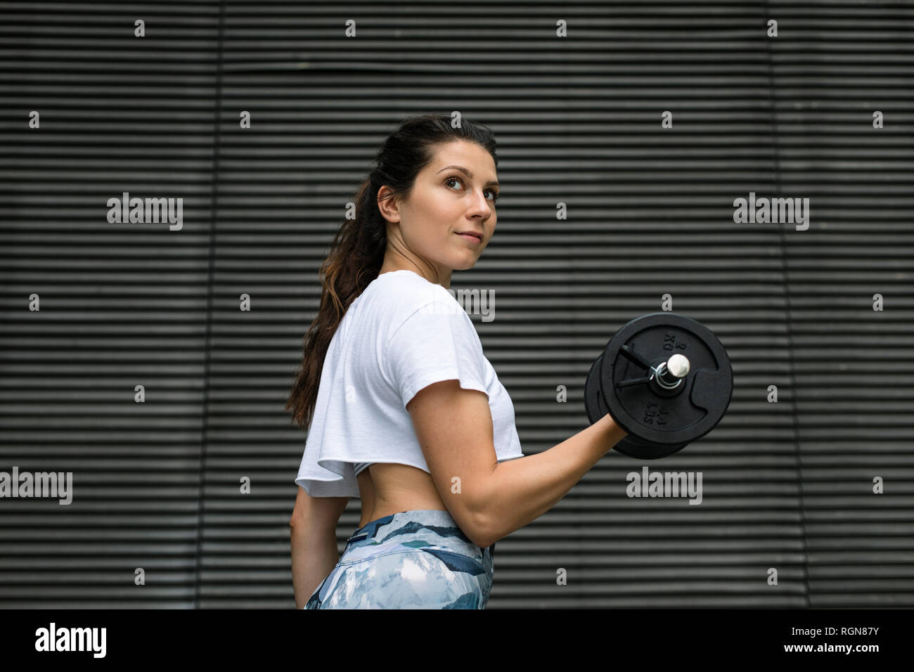 Giovane donna facendo allenamento peso all'aperto Foto Stock
