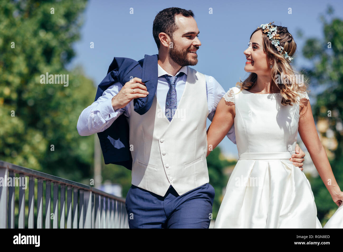 Felice coppia di sposi godendo il loro giorno di nozze in un parco Foto Stock