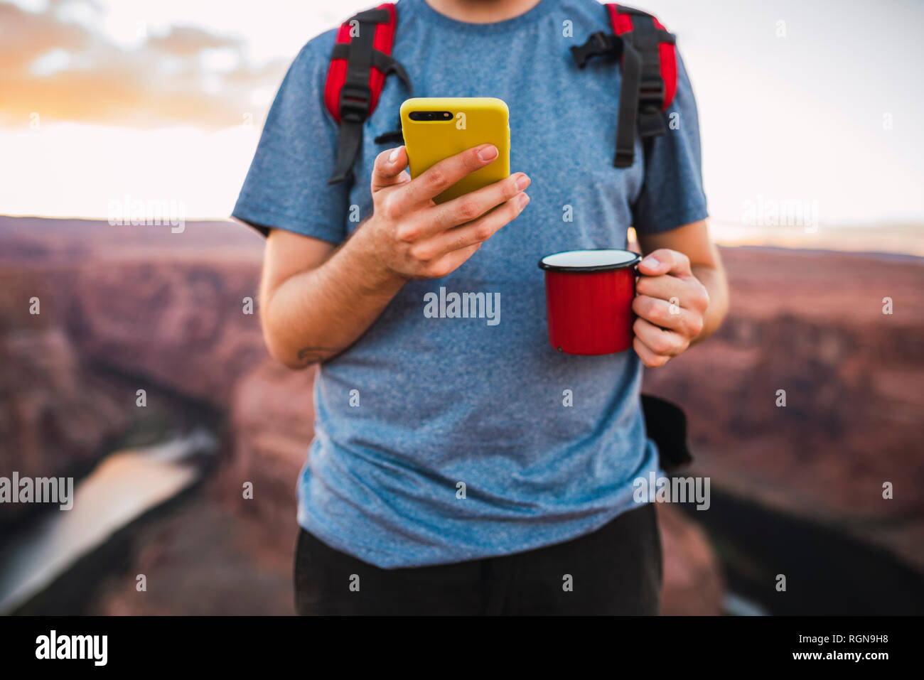 Giovane Azienda red cup e utilizza lo smartphone Foto Stock