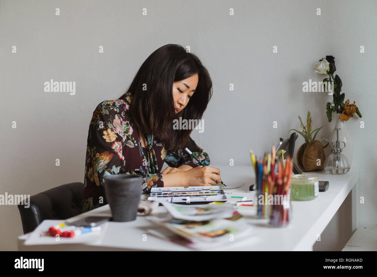 Illustrator disegno alla scrivania in un atelier Foto Stock