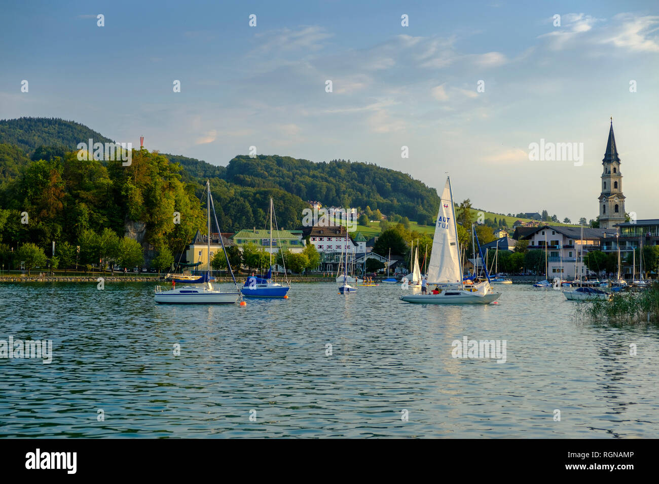 Austria, Land Salzburg, Flachgau, Mattsee, vista del villaggio con il lago, chiesa collegiata in background Foto Stock
