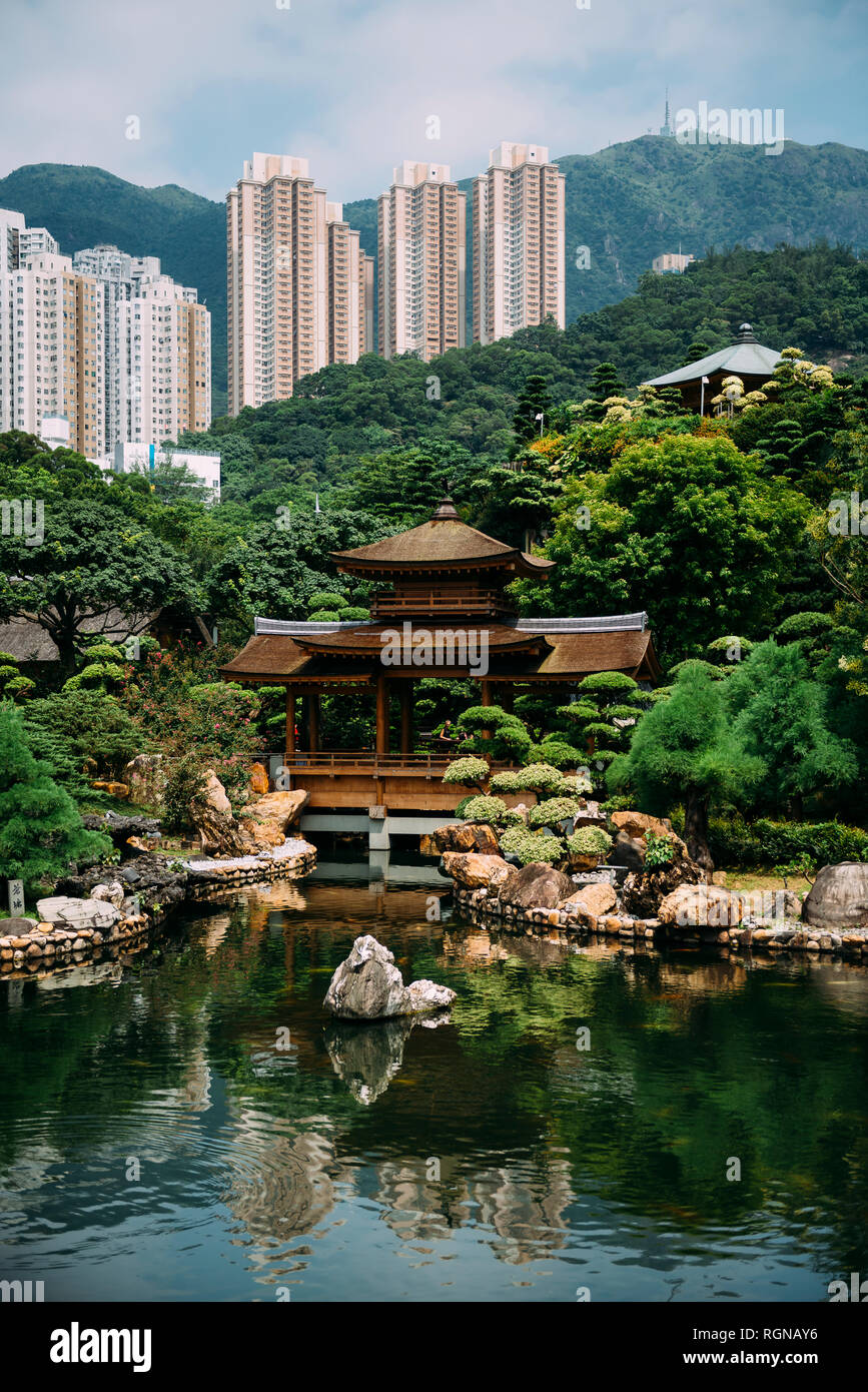 Cina, Hong Kong, Diamond Hill, laghetto in Giardino Nan Lian circondato da grattacieli Foto Stock