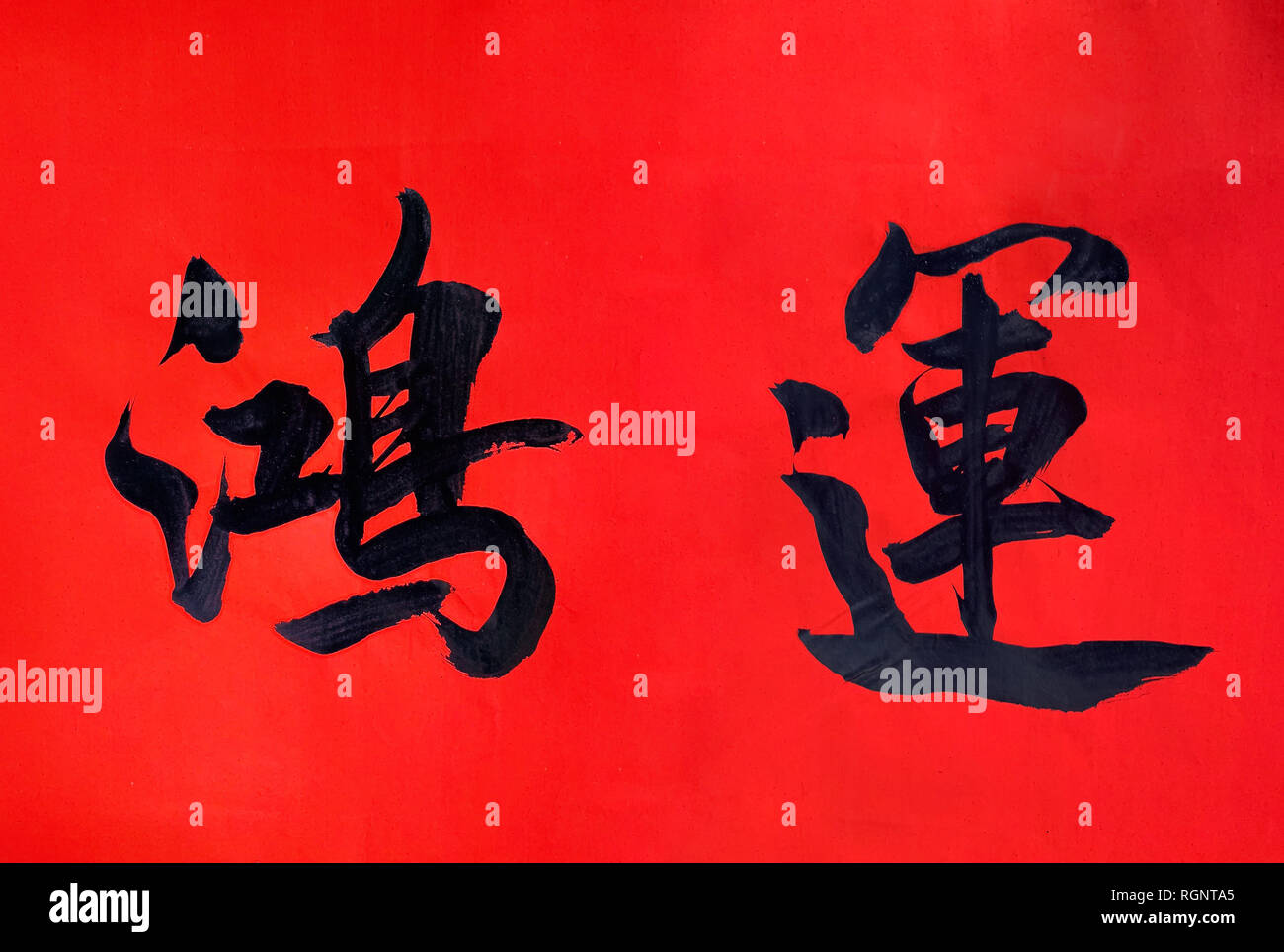 Scrittura dei caratteri cinesi rosso su carta di riso per festeggiare il nuovo anno cinese. Significato cinese - fortuna e buona fortuna, tipicamente simbolo o blessi Foto Stock