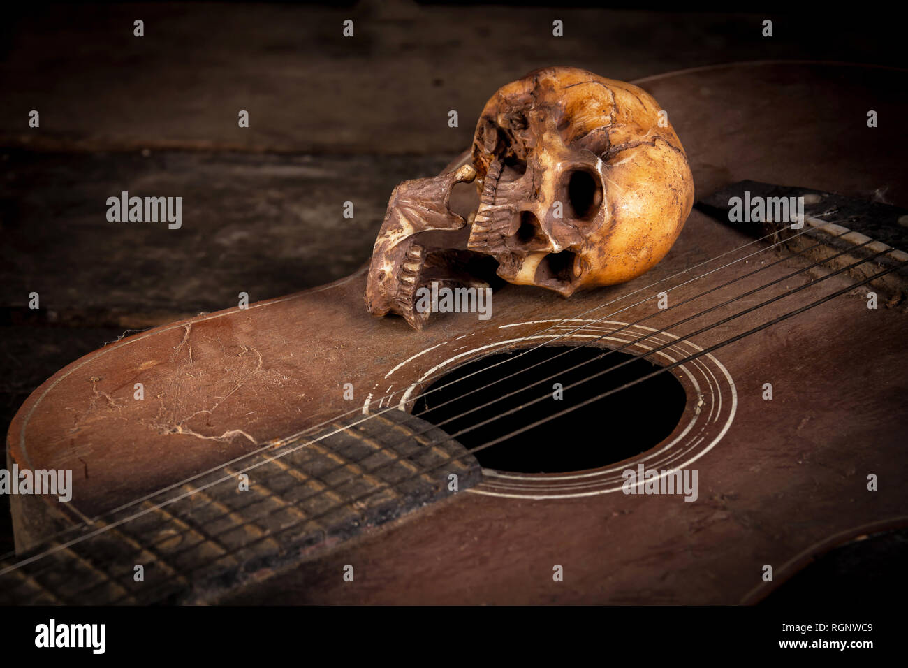 Natura morta con teschio umano su sfondo di chitarra Foto Stock