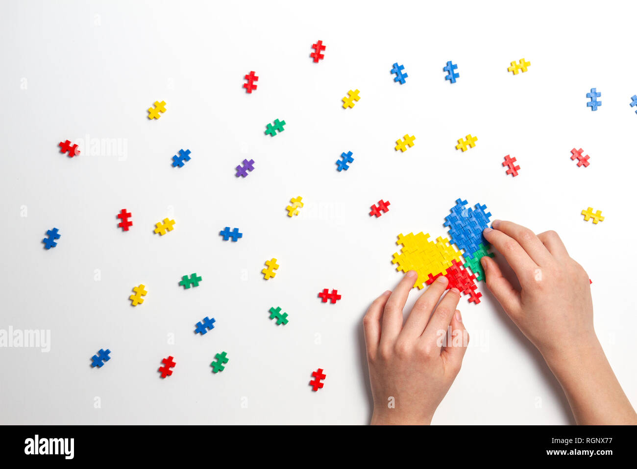 Bambino mani rendendo cuore multicolore su sfondo bianco. Vista superiore Foto Stock