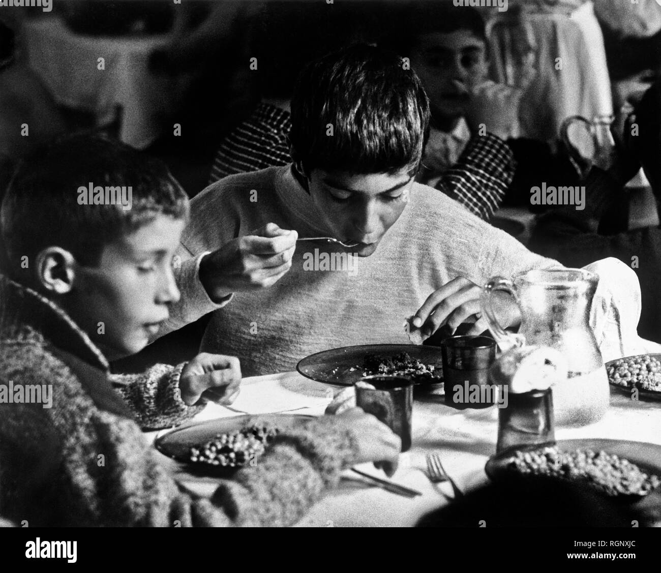 Ragazzi piccoli presso la sala da pranzo del Tci village di Valganna, Italia, 1963 Foto Stock