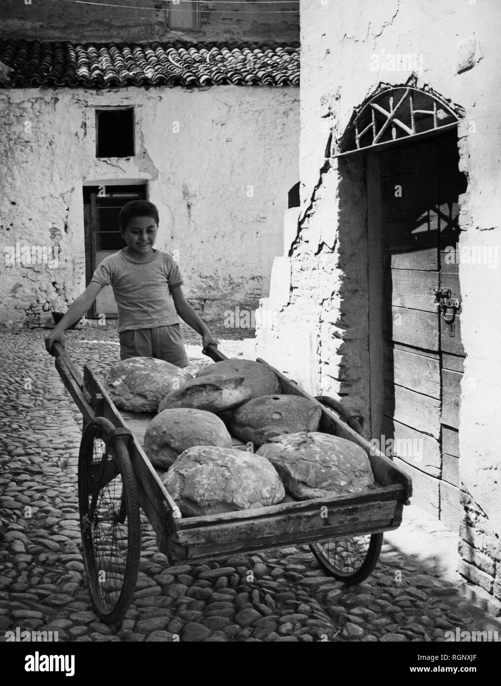 In Italia, Basilicata, un bambino che porta il pane, 1950-60 Foto Stock