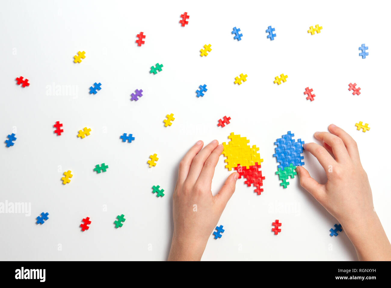 Bambino mani rendendo cuore multicolore su sfondo bianco. Vista superiore Foto Stock