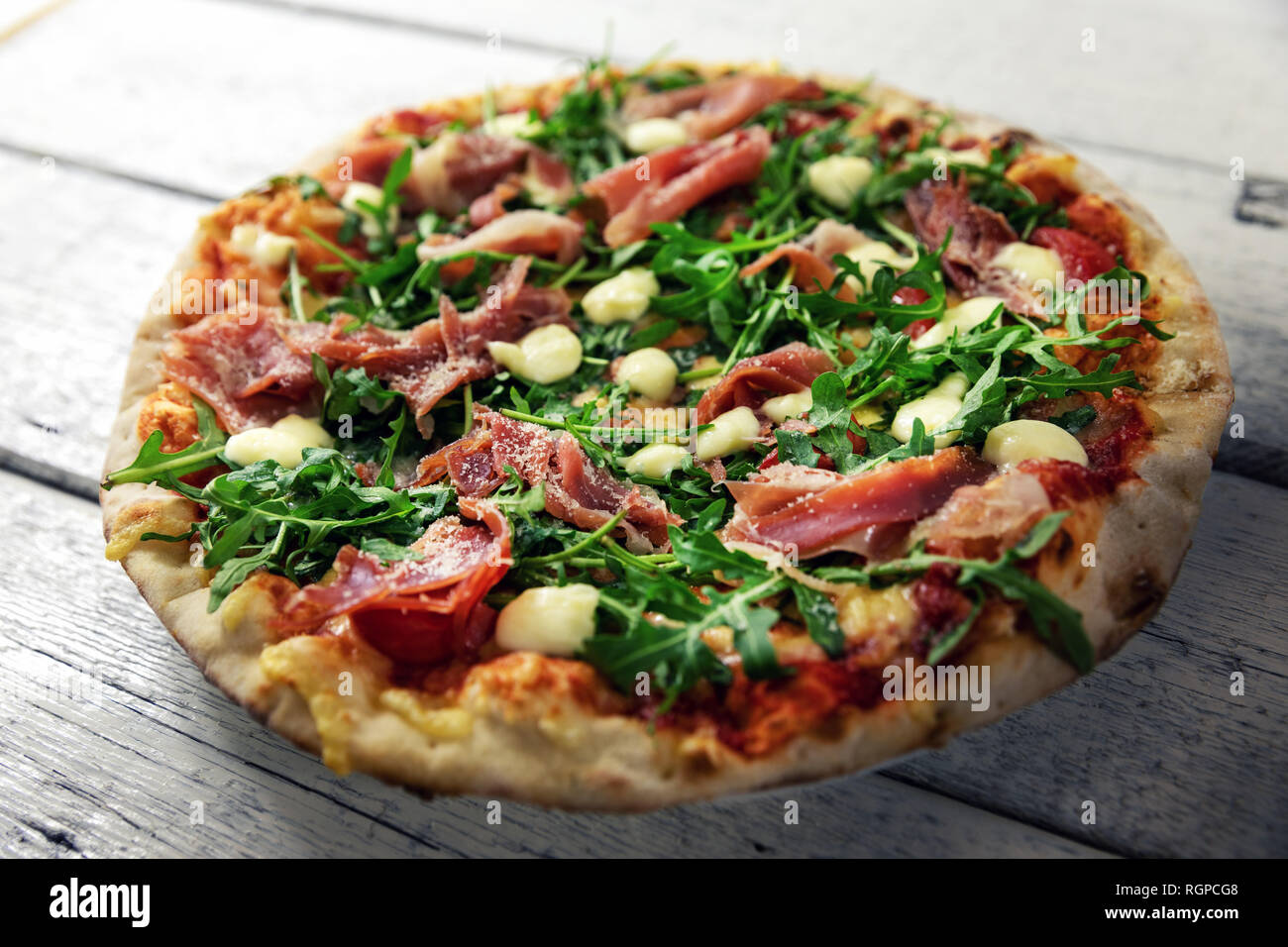 Il prosciutto la pizza con mozzarella e rucola Foto Stock