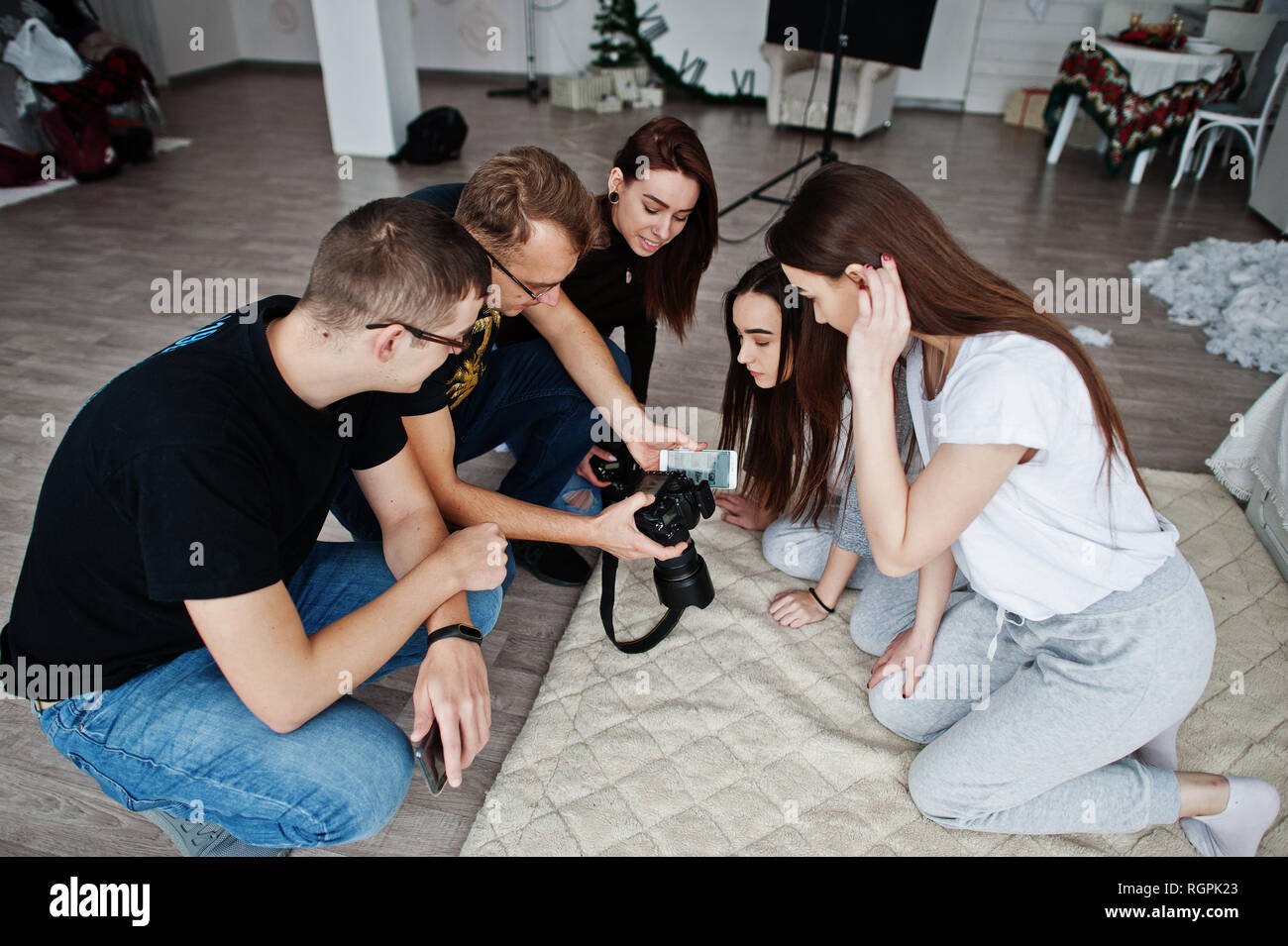 Il team di fotografi che mostra le foto sullo schermo della fotocamera per gemelli modelle Ragazze in studio. Fotografo professionista sul lavoro. Foto Stock