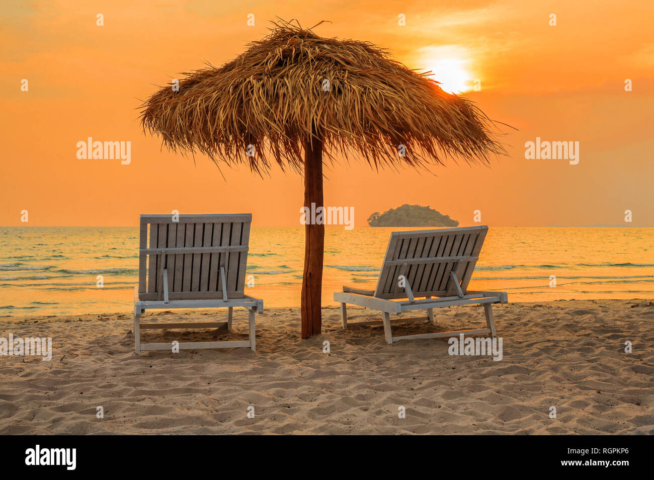 Spiaggia sedie a sdraio sotto gli ombrelloni sulla spiaggia tropicale al tramonto, in Cambogia, Sihanoukville Foto Stock