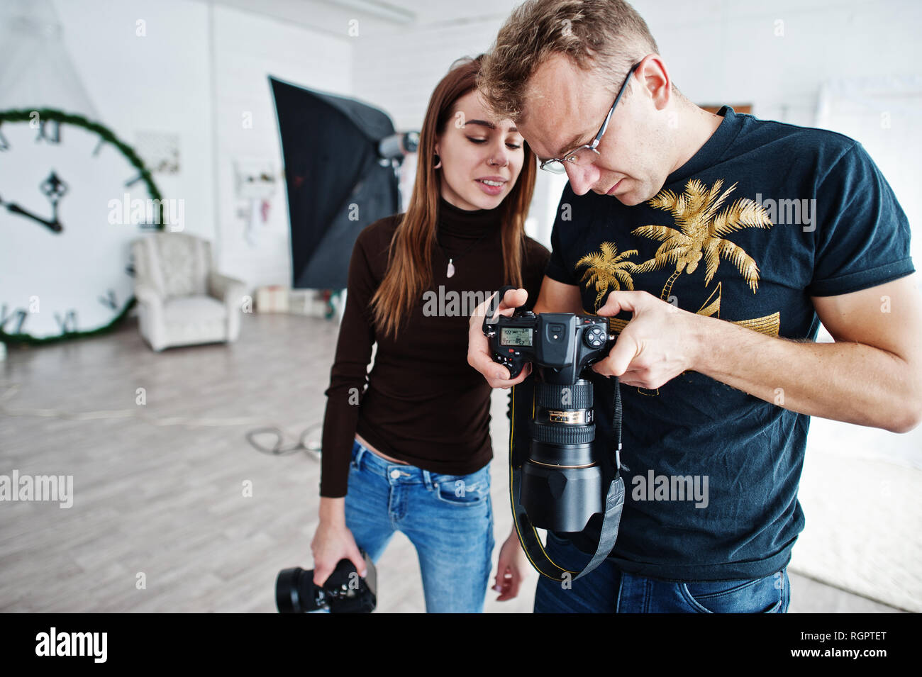 Il team di due fotografi guardando la telecamera opera finale sul materiale di studio. Foto Stock