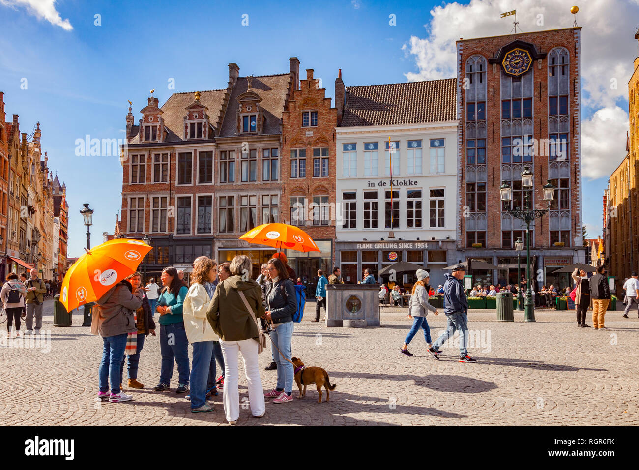 25 Settembre 2018: Bruges, Belgio - Tour di gruppo arancione sotto gli ombrelloni nel centro della città, Markt Square, su una soleggiata giornata autunnale con il glorioso b Foto Stock