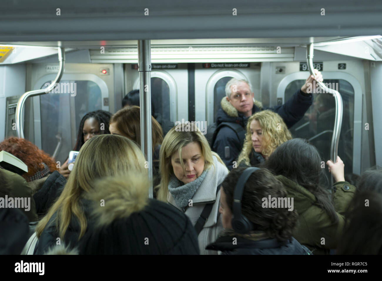 Lavoratori pendolari andando a Manhattan da Brooklyn stand ona mattina Rush Hour treno della metropolitana di New York City. Foto Stock