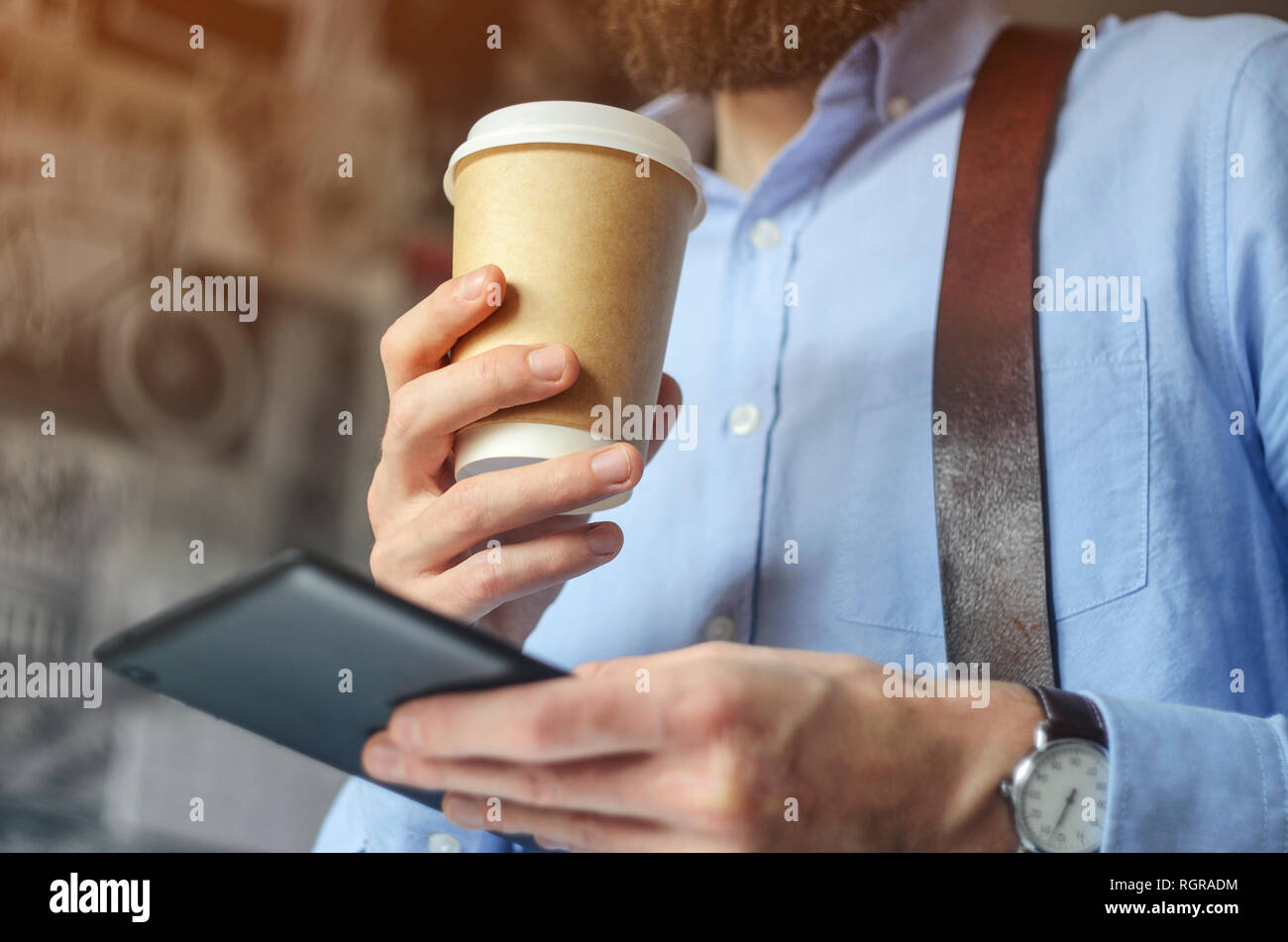 Imprenditore con tavoletta digitale e di bere il caffè. Carta dello smartphone Cup Shirt barba. Office Coffee Break Concept Foto Stock