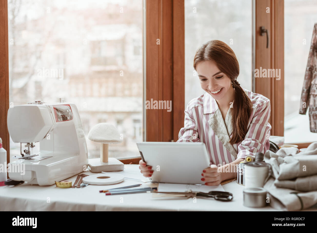 Cominciamo a creare. La stilista lavora con il computer portatile in studio di design. Caucasica donna giovane stilista all'interno di edificio per uffici Foto Stock