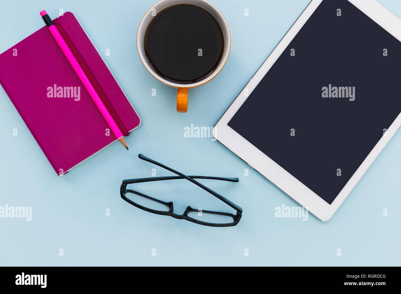 Bianco Tablet computer con tazza di caffè su blu colore di sfondo gli occhiali da lettura minima di office Foto Stock