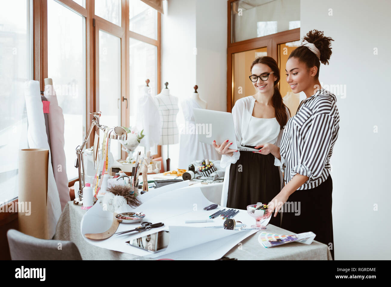 Stage di designer. Project manager consultates giovane designer. Due donne in studio di design a discutere di progetto Foto Stock