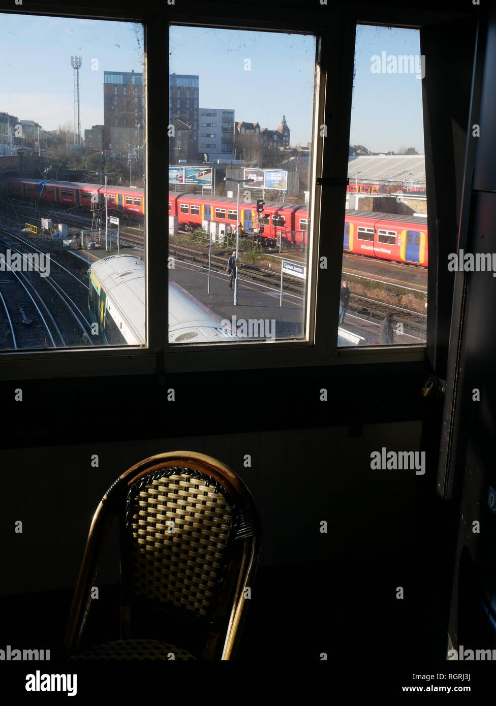 Una vista attraverso una finestra di un treno in trazione con la piattaforma a Clapham Junction stazione ferroviaria nel sud di Londra. Foto Stock