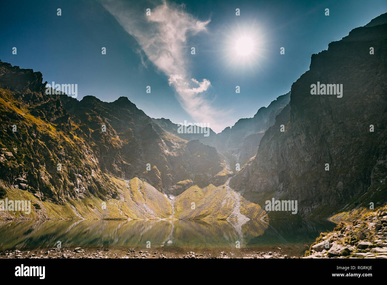 Parco nazionale dei Alti Tatra, Polonia. Lago calmo Czarny Staw sotto Rysy e Montagna estate paesaggio. Sole con raggi solari al di sopra di bellissima vista panoramica di Lak Foto Stock