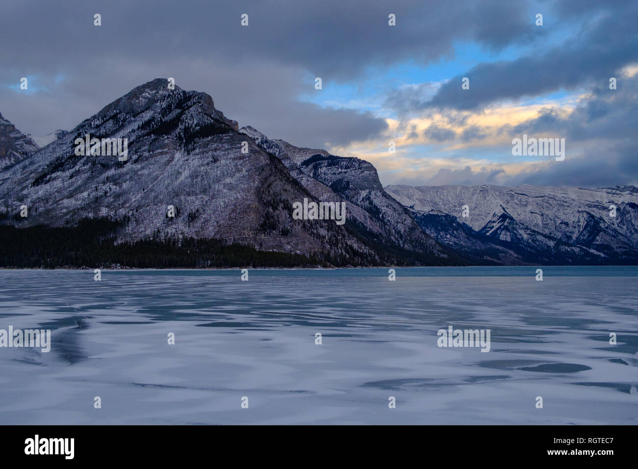 Nuvolosi cieli colorati e inverno tramonto su picchi di montagna al Lago Minnewanka, il Parco Nazionale di Banff, Alberta, Canada, 2018 Foto Stock