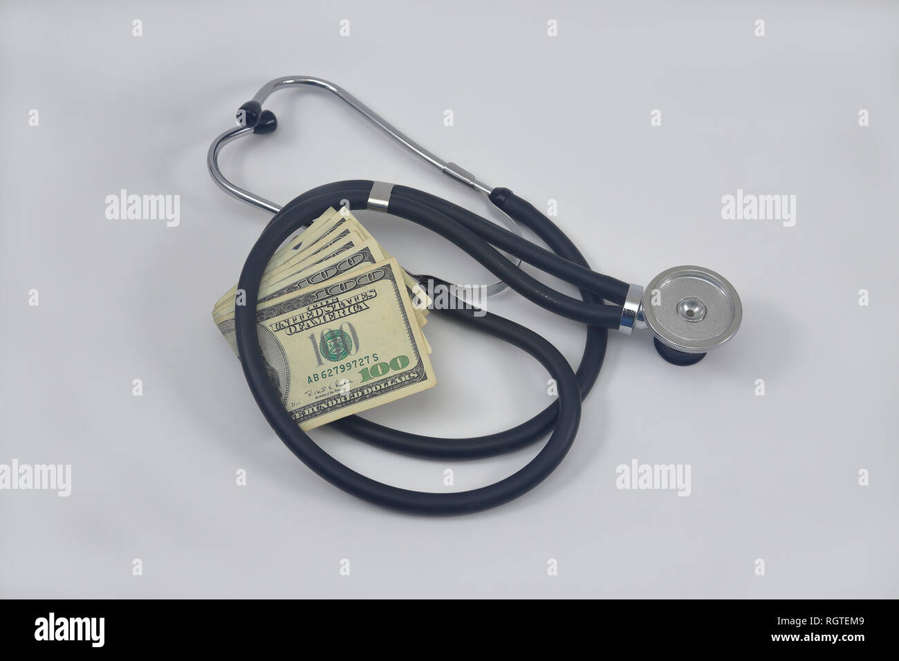 Stetoscopio medico con noi in contanti in valuta che rappresentano i costi sanitari e gli investimenti di check-up Foto Stock