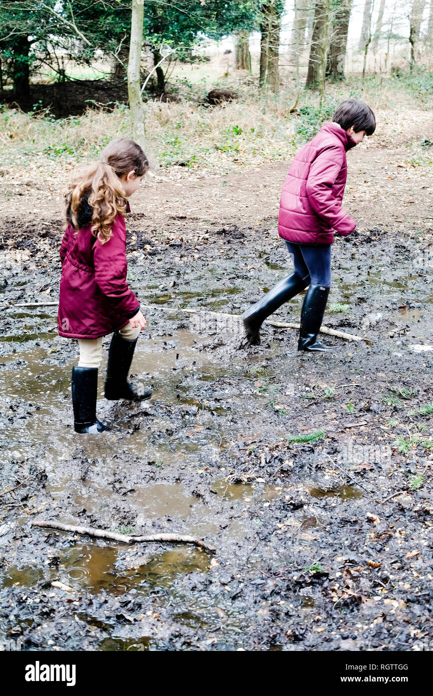 Bambini godendo un fangoso a piedi nella nuova foresta. Hampshire, Regno Unito Foto Stock