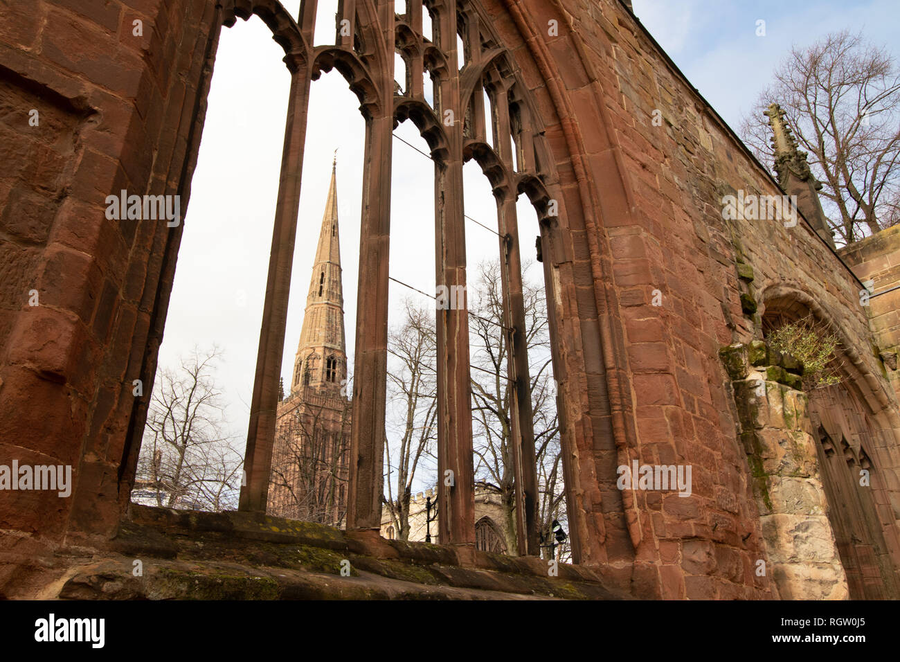 La guglia della chiesa della Santa Trinità visto attraverso le finestre di Coventry vecchia cattedrale Foto Stock