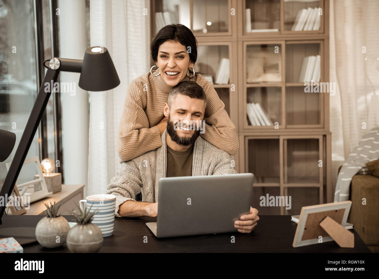 Ridendo attraente donna appoggiata sul retro del suo marito Foto Stock